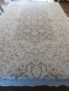 the table cloth is white and brown with an intricate design on it's edge