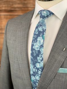 This handmade floral tie is an excellent accessory for weddings, parties, proms - an excellent gift for anyone who enjoys dressing-up dapper! Style: Slim/narrow Fabric: 100% cotton Approx. Measurements: (W) 2.4 in. x (L) 58 in. Care: Dry clean only Matching Men's Bow Tie Style: Pre-tied (w/ adjustable straps) Fabric: 100% brushed cotton Size: Mens | One size Bow measures approx. 4.75 in. x 2.4 in. Care: Dry clean only Matching Pocket Square Fabric: 100% brushed cotton Approx. 12 in. x 12 in. Dry Blue Suit And Tie Accessories For Wedding, Blue Classic Wedding Suit And Tie Accessories, Elegant Blue Suit And Tie Accessories For Wedding, Fitted Suit And Tie Accessories For Groom, Blue Dapper Suit And Tie Accessories For Party, Blue Suit And Tie Accessories For Groom, Dapper Blue Wedding Ties, Adjustable White Tie For Wedding, Blue Wedding Suit And Tie Accessories