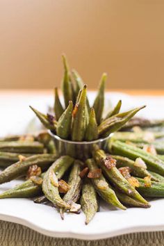 a white plate topped with green beans covered in seasoning