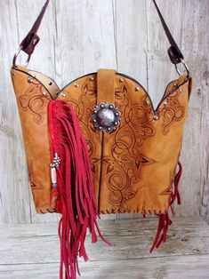 Bucket Bag Cowboy Boot Fringe PurseHand-cut FringeHand-Crafted from a Pair of BootsNo Two AlikeLeather Body/Leather strapWestern conchoSolid BaseMagnetic ClosureMeasures approx. 10”x13”FAQ'sReviews Western Style Brown Bag With Concho, Hand Tooled Leather Bags For Rodeo, Western Leather Bags For Fall, Bohemian Brown Bags With Concho, Western Bags With Concho Detail, Western Style Bags With Concho, Brown Leather Bags For Rodeo, Hand Tooled Brown Bags For Rodeo, Western Brown Bag With Fringe