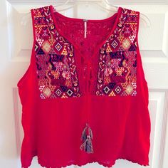 Beautiful Embroidered Front And Back Trapeze Style Tank Top. Tassle Tie In Front And Woven Details Top Front/Back And Stitched Hem. Size L Measurement From Shoulder To Hem 21 1/2” Like New (Never Worn) Red Sleeveless Tops With Floral Embroidery, Sleeveless Red Tops With Floral Embroidery, Red Sleeveless Top With Floral Embroidery, Bohemian Red Embroidered V-neck Top, Red Bohemian V-neck Embroidered Top, Red Tops With Floral Embroidery For Festivals, Red Embroidered Festival Tops, Red V-neck Embroidered Summer Top, Red Floral Embroidered Top For Festival