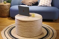 a blue couch sitting in front of a laptop computer on top of a round table