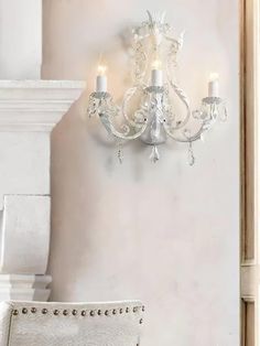 a white chair sitting next to a chandelier