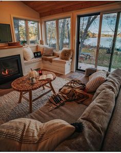 a living room filled with furniture and a fire place in front of a large window