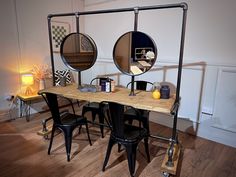 a table with three mirrors on it and some chairs in front of the mirror are sitting next to each other