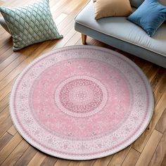 a round rug on the floor in front of a couch with pillows and throw pillows