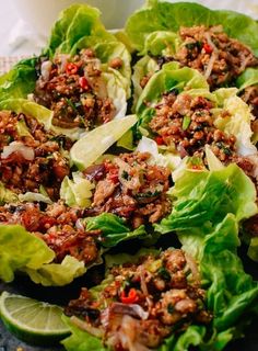 lettuce wraps filled with meat and garnishes on top of a table