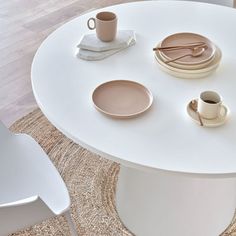 a white table with plates, cups and saucers sitting on it's side