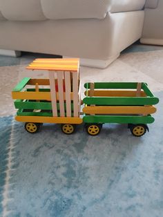 a toy truck made out of popsicle sticks sitting on top of a blue rug