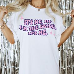 a woman wearing a white t - shirt that says it's me, i'm the bride its me