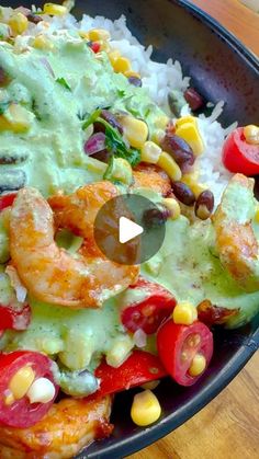 a bowl filled with shrimp, rice and veggies on top of a wooden table