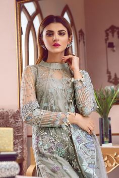 Beautiful embroidered net dress is presented for party and casual wear. This elegant attire in grey color is showing its grace with embroidered and sequinned center and side panels for shirt. Shirt is presented with elegant sequinned and embroidered net sleeves. Embroidered & sequined net borders are attached for front, back and sleeves. Dress is paired with dyed inner shirt. Trouser: This beautiful embroidered net dress is paired with silk trouser in matching color giving an stunning touch Unstitched Organza Dress With Sequins, Designer Dresses With Resham Embroidery On Net, Semi-stitched Embroidered Party Dress, Designer Net Party Dresses, Party Wear Sequin Net Dresses, Embellished Net Dress For Eid, Unstitched Net Dress With Dabka Work, Unstitched Net Dress For Party, Unstitched Net Party Dress