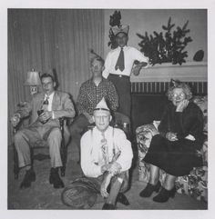 an old black and white photo of people dressed up in costumes, sitting on couches