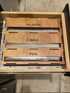 two knives in a wooden box with labels on them that say plastic, wax and foil