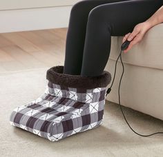 a woman is sitting on the couch with her foot in a boot