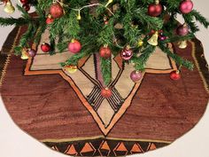 a christmas tree skirt with ornaments on it