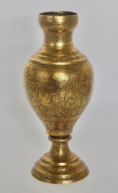 a gold vase sitting on top of a white table