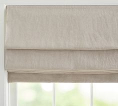 an open window with roman blinds in the corner and white walls behind it, all made out of linen