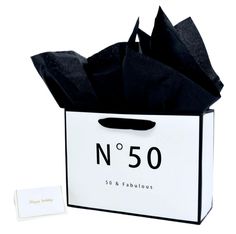 a black and white shopping bag with the number 50 on it next to a card