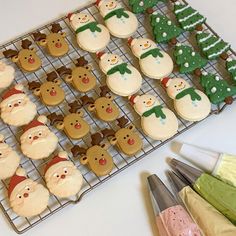 some decorated cookies are on a cooling rack and next to other decorations, such as christmas trees