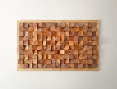 a wooden wall hanging on the side of a white wall