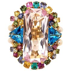 Wow! A guaranteed stunner! This large cocktail ring features a large rectangular shaped pink kunzite weighing 30 carats. Around the center stone is a bouquet of multicolored gemstones which include two fine paraiba tourmalines on the top and bottom of the ring. Adding to that there are 4 round brilliant cut diamonds, 4 natural pearls, 2 larger blue topaz on the sides, and multicolored sapphires all round the rest of the piece. Made in 18k yellow gold it is guaranteed that another one of these ri Birth Stones, Pink Kunzite, Expensive Jewelry Luxury, Rainbow Jewelry, Gold Cocktail Ring, Gold Cocktail, Expensive Jewelry, Colored Gems, Crown Jewels