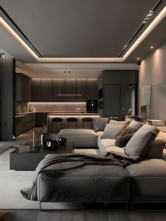 a large living room with couches, tables and lamps on the ceiling is lit by recessed lights