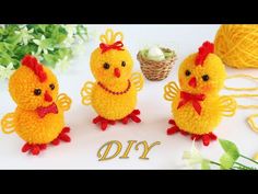 three small stuffed chickens sitting next to each other on a table with yarn and flowers