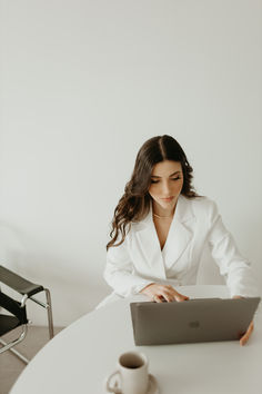 a woman sitting at a table using a laptop computer