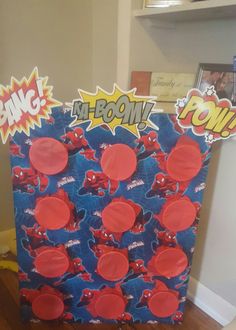 a cardboard box with red and blue buttons on it sitting on top of a hard wood floor