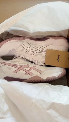 a pair of white and pink shoes in a box