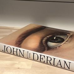 a book sitting on top of a wooden table next to a white wall and floor