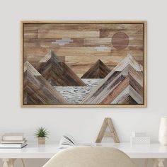 a desk with a chair and a painting on the wall above it that says mountain range