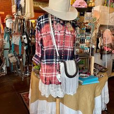 a woman's clothing and hat on display in a store with many other items