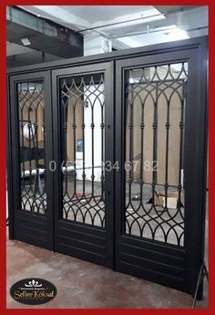 an ornate glass front door in black with red frame and mirror panels on the doors