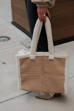 Beige vegan leather handbag. Held by an ivory sherpa trim. This item is Final Sale. Lauren Nicole, Leather Handbag, Leather Handbags, Final Sale, Vegan Leather, Trim, Tote Bag, Purses And Bags, Handbags