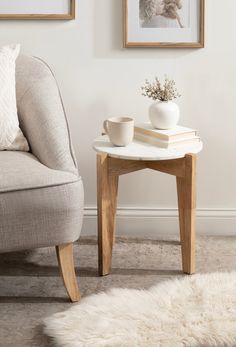 a living room with two pictures on the wall and a coffee table next to it