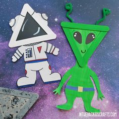 paper cut out of an alien and a spaceman