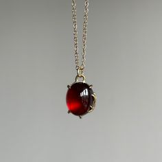 Radiating tender warmth, an incandescent garnet cabochon is held within golden branches in this pendant that evokes a feeling of eternity. 14k yellow gold, fine silver Garnet, 7.35ct, 10mm x 12mm (3/8" x 7/16")Chain is 18" long Elegant Amber Oval Cabochon Necklace, Elegant Gold Garnet Cabochon Jewelry, Formal Yellow Gold Garnet Necklaces, Formal Yellow Gold Garnet Necklace, Elegant Garnet Oval Cabochon Jewelry, Elegant Jewelry With Oval Cabochon Garnet, Yellow Gold Garnet Necklaces With Oval Shape, Yellow Gold Oval Garnet Necklace, Formal Amber Necklace In 14k Gold