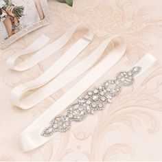 Beautiful Sash with crystal rhinestone, perfect with any wedding gown and formal dress. ✧ Ribbon Width approx 1/2 inch (2cm) ✧ Ribbon Length approx 98 inches (250cm) ✧ Rhinestone length approx 9 inches (23 cm), widest section approx 1  1/2 inches (4.5cm) ✧ Color ribbons not listed in the options list can be custom made to order Elegant White Sashes With Rhinestones, Formal Fitted Sash With Rhinestones, Formal White Crystal Sash, White Crystal Sash For Formal Occasions, White Crystal Sashes For Formal Occasions, White Crystal Wedding Sash, White Rhinestones Bridesmaid Bridal Accessories, White Rhinestone Sashes For Bridesmaids, White Bridesmaid Sashes With Rhinestones