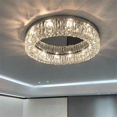 a circular crystal chandelier hanging from the ceiling in a room with white walls