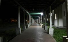 an empty covered walkway at night with lights on