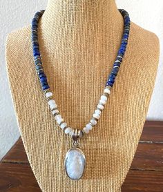 This necklace is made up of 4x6mm faceted Lapis Lazuli and Moonstone beads that has silver spacers throughout.  The large, oval moonstone pendant is set in sterling silver and has a smooth finish. It is open on the back to allow for more light and iridescence. The pendant is 1.75" including bale and the moonstone portion alone is 1.25". This is an understated, yet striking piece of jewelry. Coordinating bracelet available made to length specifications ($60), inquiries welcome. Free shipping via FedEx to continental U.S. only.  Necklace arrives in a complementary box suitable for gifting. All sales final. Silver Oval Beaded Necklaces, Silver Faceted Oval Beads Jewelry, Silver Faceted Jewelry With Oval Beads, Faceted Silver Jewelry With Oval Beads, Spiritual Silver Faceted Beaded Necklaces, Silver Jewelry With Faceted Beads Made Of Lapis Lazuli, White Oval Gemstone Beads Necklaces, Silver Jewelry With Faceted Beads In Lapis Lazuli, Silver Beaded Necklaces With Lapis Lazuli Natural Stones