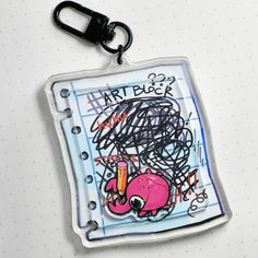 a piece of art is hanging on a keychain that has been drawn onto