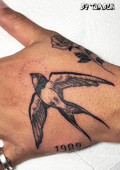 a hand with a hummingbird tattoo on it's left arm and the number 1909 written in black ink