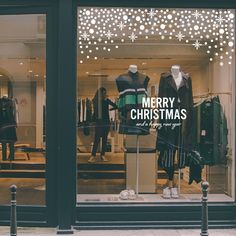 a store front window with mannequins and christmas decorations