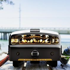 an outdoor bbq grill sitting on top of a wooden table