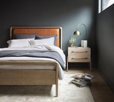 a bedroom with black walls and wooden furniture