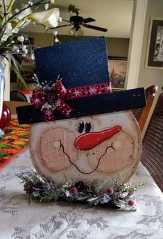 a wooden snowman sitting on top of a table