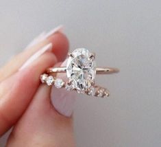 a woman's hand holding an engagement ring with a diamond on the top and side